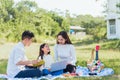 Happy family having fun outdoor on picnic using laptop computer technologies relaxing to open song Royalty Free Stock Photo