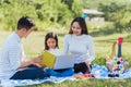 Happy family having fun outdoor on picnic using laptop computer technologies relaxing to open song Royalty Free Stock Photo