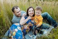 Happy family having fun outdoors in grass. Family enjoying life together at meadow. Mother, father, little boy smiling Royalty Free Stock Photo