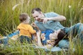 Happy family having fun outdoors in grass. Family enjoying life together at meadow. Mother, father, little boy smiling while Royalty Free Stock Photo