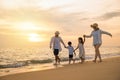 Happy family having fun running on a sandy beach at sunset time Royalty Free Stock Photo