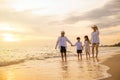 Happy family having fun running on a sandy beach at sunset time Royalty Free Stock Photo