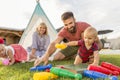 Parents having fun playing bowling with little children while camping in the backyard Royalty Free Stock Photo