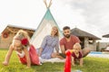 Parents playing with children while camping in the backyard