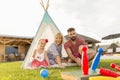 Parents playing bowling with children while camping in the backyard Royalty Free Stock Photo