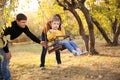 Happy family having fun on a swing ride at a garden a autumn day Royalty Free Stock Photo