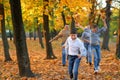 Happy family having holiday in autumn city park. Children and parents running, smiling, playing and having fun. Bright yellow Royalty Free Stock Photo