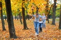 Happy family having holiday in autumn city park. Children and parents running, smiling, playing and having fun. Bright yellow Royalty Free Stock Photo