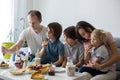 Happy family, having pancakes for breakfast, eating in living room, talking and laughing Royalty Free Stock Photo