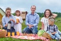 Happy family having picnic in meadow on a sunny day. Family Enjoying Camping Holiday In Countryside Royalty Free Stock Photo