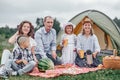 Happy family having picnic in meadow on a sunny day. Family Enjoying Camping Holiday In Countryside. Royalty Free Stock Photo