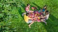 Happy family having picnic in park, parents with kids sitting on grass and eating healthy meals outdoors, aerial view from above Royalty Free Stock Photo