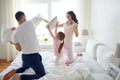 Happy family having pillow fight in bed at home Royalty Free Stock Photo