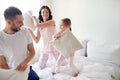 Happy family having pillow fight in bed at home Royalty Free Stock Photo