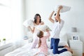 Happy family having pillow fight in bed at home Royalty Free Stock Photo