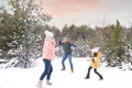 Happy family having snowball fight outdoors on winter day. Christmas vacation Royalty Free Stock Photo