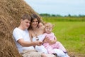 Happy family in haystack or hayrick Royalty Free Stock Photo