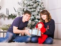 Happy family holding Christmas gifts near Xmas tree. Baby, mother and father having fun at home Royalty Free Stock Photo