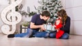 Happy family holding Christmas gifts near Xmas tree. Baby, mother and father having fun at home Royalty Free Stock Photo