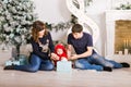 Happy family holding Christmas gifts near Xmas tree. Baby, mother and father having fun at home Royalty Free Stock Photo