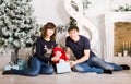 Happy family holding Christmas gifts near Xmas tree. Baby, mother and father having fun at home Royalty Free Stock Photo