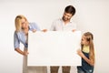 Happy Family Holding Empty White Board Standing On White Background Royalty Free Stock Photo