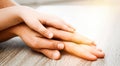 Happy family holding hands at wooden table, closeup. Banner design Royalty Free Stock Photo