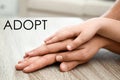 Happy family holding hands at table indoors, closeup. Child adoption concept Royalty Free Stock Photo