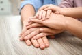 Happy family holding hands at table indoors, closeup view Royalty Free Stock Photo