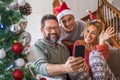 Happy family at home during christmas eve day enjoy a video phone call with friends and parents - concept of happy people and Royalty Free Stock Photo