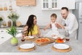 Happy family in home kitchen married couple with small child and pregnant woman Royalty Free Stock Photo