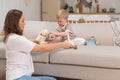 Happy family at home. Mother and baby boy playing with toys in couch at home indoors. Little toddler child and Royalty Free Stock Photo