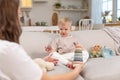 Happy family at home. Mother and baby boy playing with toys in couch at home indoors. Little toddler child and Royalty Free Stock Photo