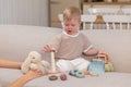 Happy family at home. Mother and baby boy playing with toys in couch at home indoors. Little toddler child and Royalty Free Stock Photo