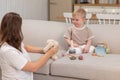 Happy family at home. Mother and baby boy playing with toys in couch at home indoors. Little toddler child and