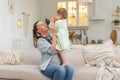 Happy family at home. Mother lifting in air little toddler child daughter. Mom and baby girl playing having fun together Royalty Free Stock Photo