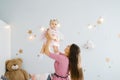 Happy family at home in the nursery. The mother throws the child daughter and laughs Royalty Free Stock Photo