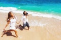 Young couple run by white sand beach along sea surf Royalty Free Stock Photo