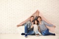 Happy family with house model and key of their new home under plaid indoors Royalty Free Stock Photo