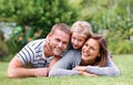 Happy family huddle. Portrait of a happy family of three lying outside on the grass. Royalty Free Stock Photo