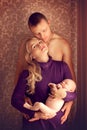 Happy family - husband, wife and newborn baby posing at home by Royalty Free Stock Photo