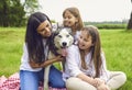 Happy family with husky dog lying on grass in summer park. Royalty Free Stock Photo