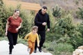 Happy family jogging in the summertime. Smiling young couple with their cute daughter doing sport Royalty Free Stock Photo