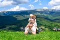 Happy family: joyful father, mother and two sons are lying on the green grass against the background of the forest, mountains and Royalty Free Stock Photo