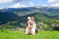 Happy family: joyful father, mother and two sons are lying on the green grass against the background of the forest, mountains and Royalty Free Stock Photo