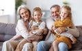 Happy family joyful little children hugging embracing with positive senior grandparents at home