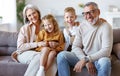 Happy family joyful little children hugging embracing with positive senior grandparents at home Royalty Free Stock Photo