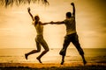 Happy family jumping on the beach on the dawn time