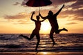 Happy family jumping on the beach at the sunset time. Royalty Free Stock Photo