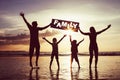 Happy family jumping on the beach at the sunset time. Royalty Free Stock Photo